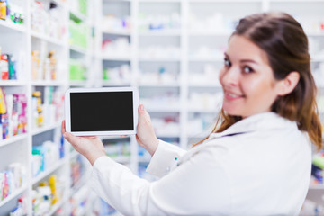 Fototapeta na wymiar Female pharmacist holding a digital tablet smiling focus on hands and tablet screen