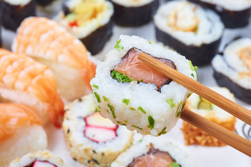 Sushi set. Chopsticks with portion of sushi