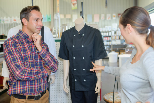 woman choosing chefs tunic in commercial wholesale store