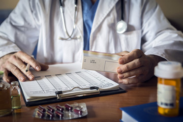 Doctor writing patient notes on a medical examination or prescription