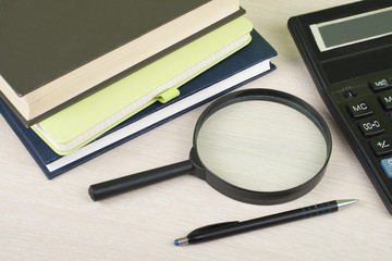 Home savings, budget concept. Notepad, pen, calculator,magnifying glass on wooden office desk table.