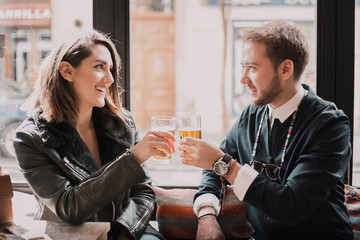 Couple toasting at the bar. Drinking beer and having a good time with lots of love.