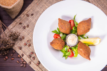 Meat meatballs with stuffing of mutton forcemeat, are served with pine nuts and onions