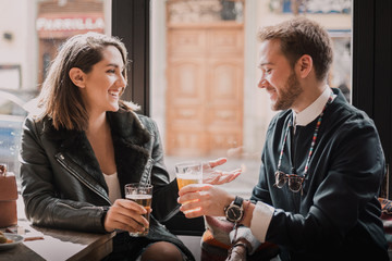 Couple toasting at the bar. Drinking beer and having a good time with lots of love.
