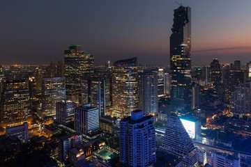 Scenic view MahaNakhon and many other lit skyscrapers in downtown Bangkok, Thailand, in the evening from above. © tuomaslehtinen