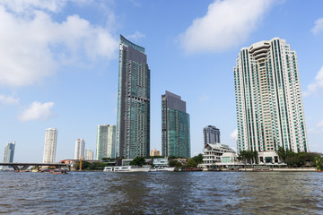 Tall and modern skyscrapers along the Chao Phraya River in Bangkok, Thailand.