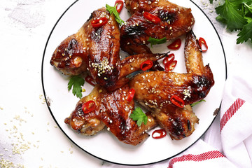 Spicy chicken wings with teriyaki sauce and sesame seeds on a vintage plate .Top view with space for text.