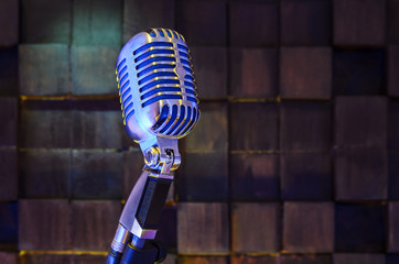 Retro microphone on wood brown background in sound recording room. On air concept. Music background...