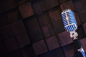 Retro microphone on wood brown background.
