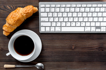 woman breakfast with coffee and croissant in office on wooden background top view mockup