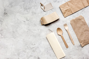 food delivery with paper bags and flatware on stone table background top view mockup