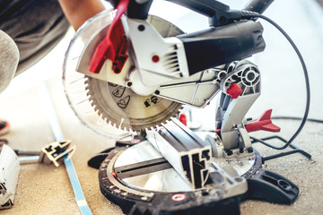 industrial engineer working on cutting a aluminium and steel with compound mitre saw with sharp, circular blade