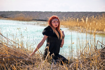 Elf women with fiery hair on nature. Beautiful young fantasy girl. Cosplay character
