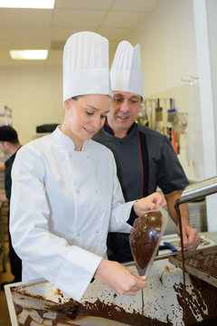 two chefs in teamwork - preparing chocolate stuffing