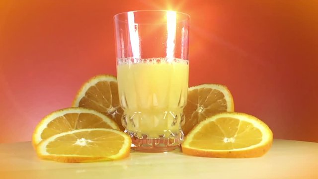 Pouring orange juice into glass shooting on the turning table