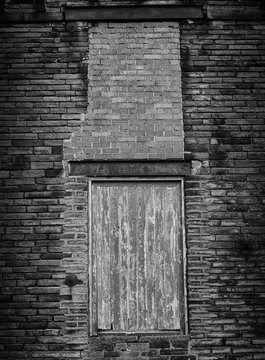 boarded up windows in a brick wall
