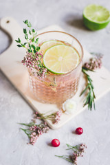 natural cocktail with berry and cut lime on stone desk background