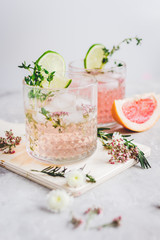 pink fresh cocktail with grape-fruit and cut lime on stone desk background