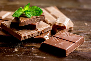 chopped chocolate pieces with mint for dessert wooden desk background