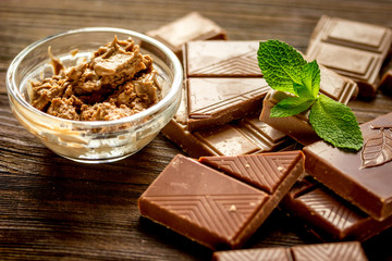black and milk chocolate bars with mint dark wooden table background