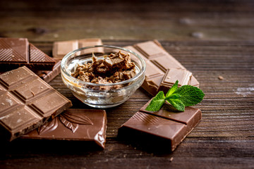 chopped chocolate pieces with mint for dessert wooden desk background