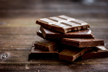 black and milk chocolate bars dark wooden table background