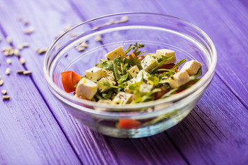 Tasty fresh salad on purple wooden table. Food