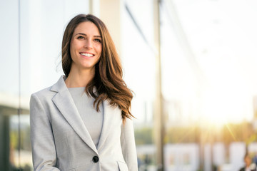 Bright sunny vibrant portrait of beautiful woman business executive style in downtown urban area