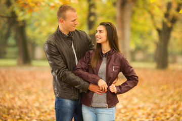 Fototapeta premium Young couple in love looking each other in a park