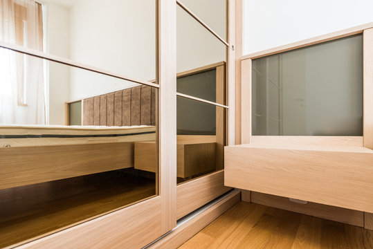 Closeup Of Sliding Door Mirror Wardrobe And Night Table In Bedroom Interior