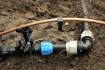 Horticultural irrigation pipes on garden soil
