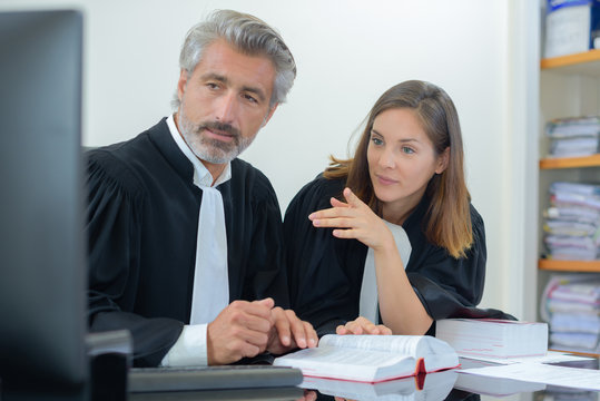 Male and female barristers looking at computer screen
