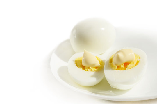 Boiled eggs in white plate against white background