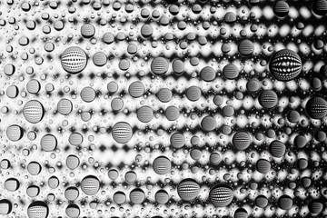 Abstract lines through drops of water on a glass macro 