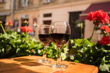 Two glasses of red wine on the vibrant restaurant background. Selective focus.