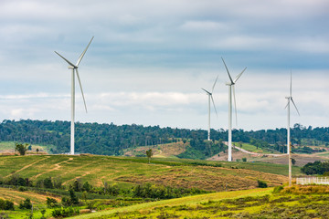 Wind turbines generate electricity to reduce global warming. Located on the hill.