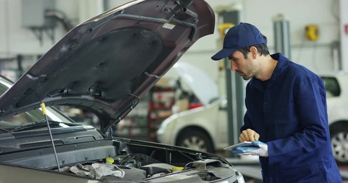 Specialist auto mechanic in the car service, checks the car, engine, engine, carburetor. Concept: repair of machines, fault diagnosis, repair specialist, technical maintenance and on-board computer.