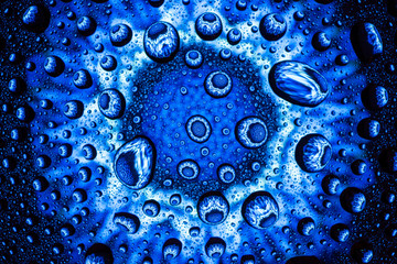 Abstract flower through a drops of water on a glass, macro view