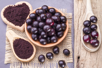 Fruits and acai powder originating from the Amazon on wood (Euterpe oleracea)