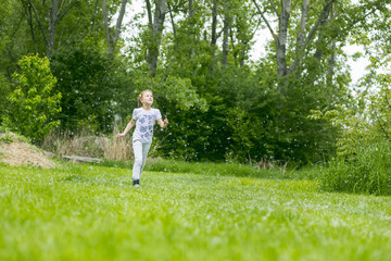 Little girl  playing with poplar fluff on the green park outdoor.