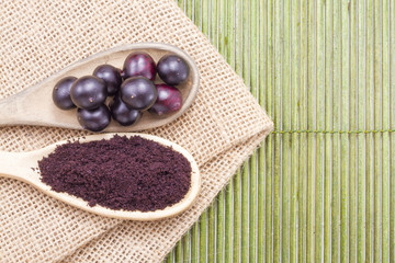 Fruits and acai powder originating from the Amazon on wood (Euterpe oleracea)