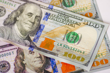 ckose up of Us 100 american dollar money bills spread aroundo over a white background