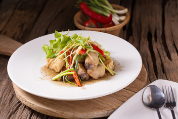 Piece of fried King Mackerel fish with fish sauce, served with spicy seafood sauce, thai style