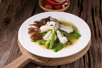 Stir fried kale with fresh squid on white dish