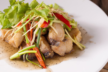 Piece of fried King Mackerel fish with fish sauce, served with spicy seafood sauce, thai style