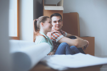 Couple moving in house sitting on the floor