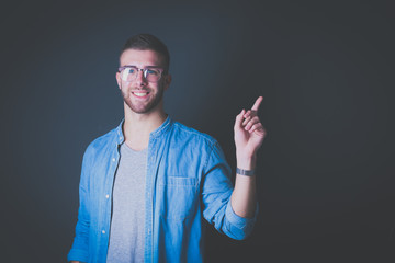 Portrait of a smiling young man pointing up