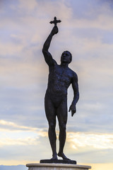 Bronze sculpture of a man holding a cross sign in Ohrid town, Macedonia