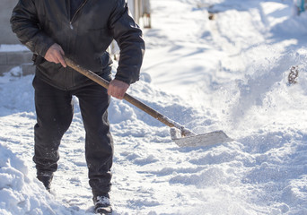 Worker cleans snow shovel