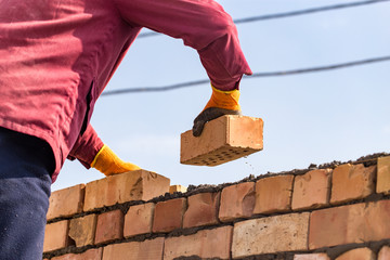Worker builds a brick wall in the house